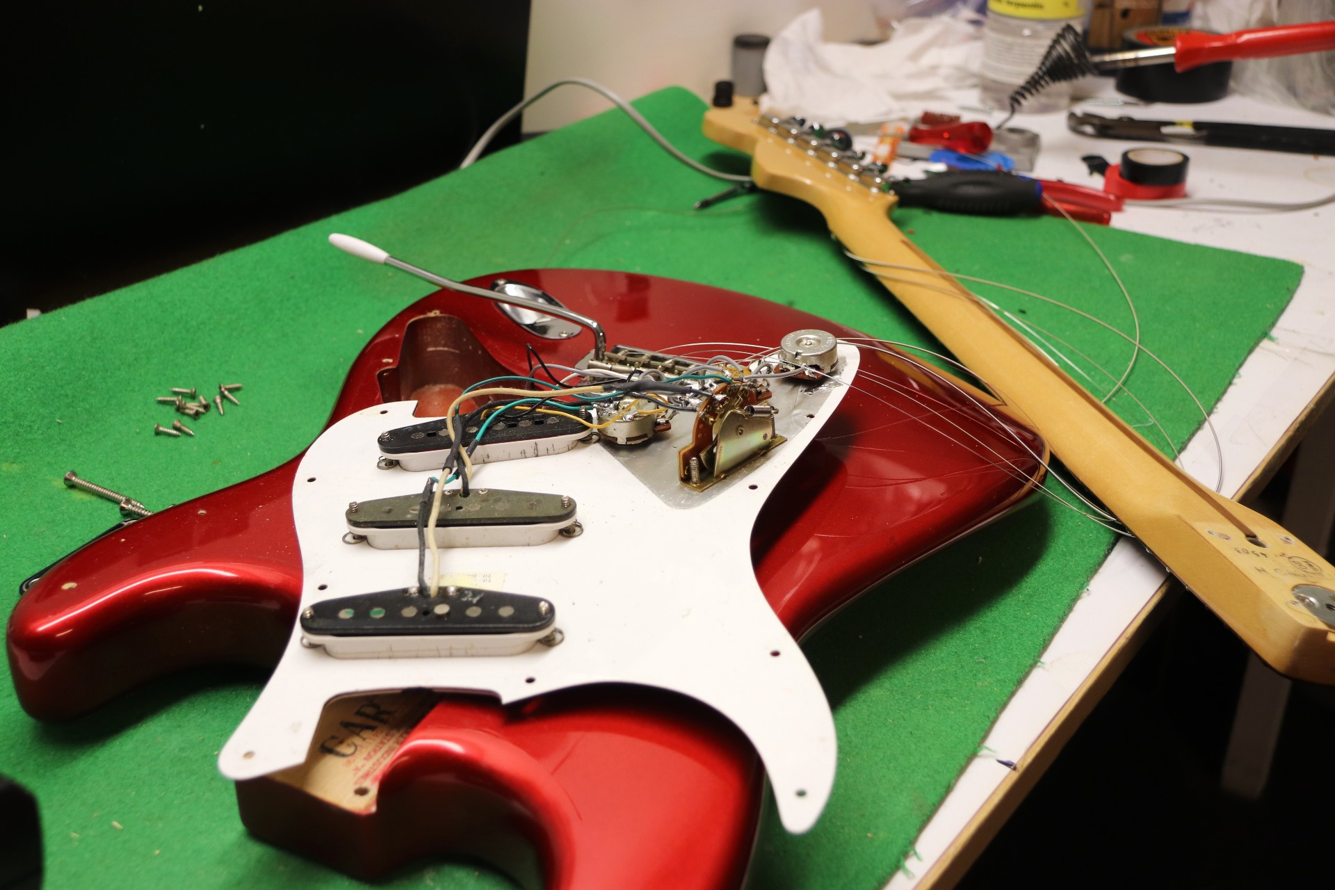 Lasse har mange prosjekter på gang, akkurat nå holder han på å datere en gammel gitar på reparasjonsverkstedet. Ellers går det mye i å reparere gitarer med blant annet knekt hals, da må det limes, tvinges og lakkeres for å få det pent igjen.