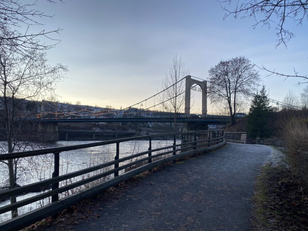 Rim i gresset og litt småglatt på asfalten langs elvepromenaden ved møllesteinene.
