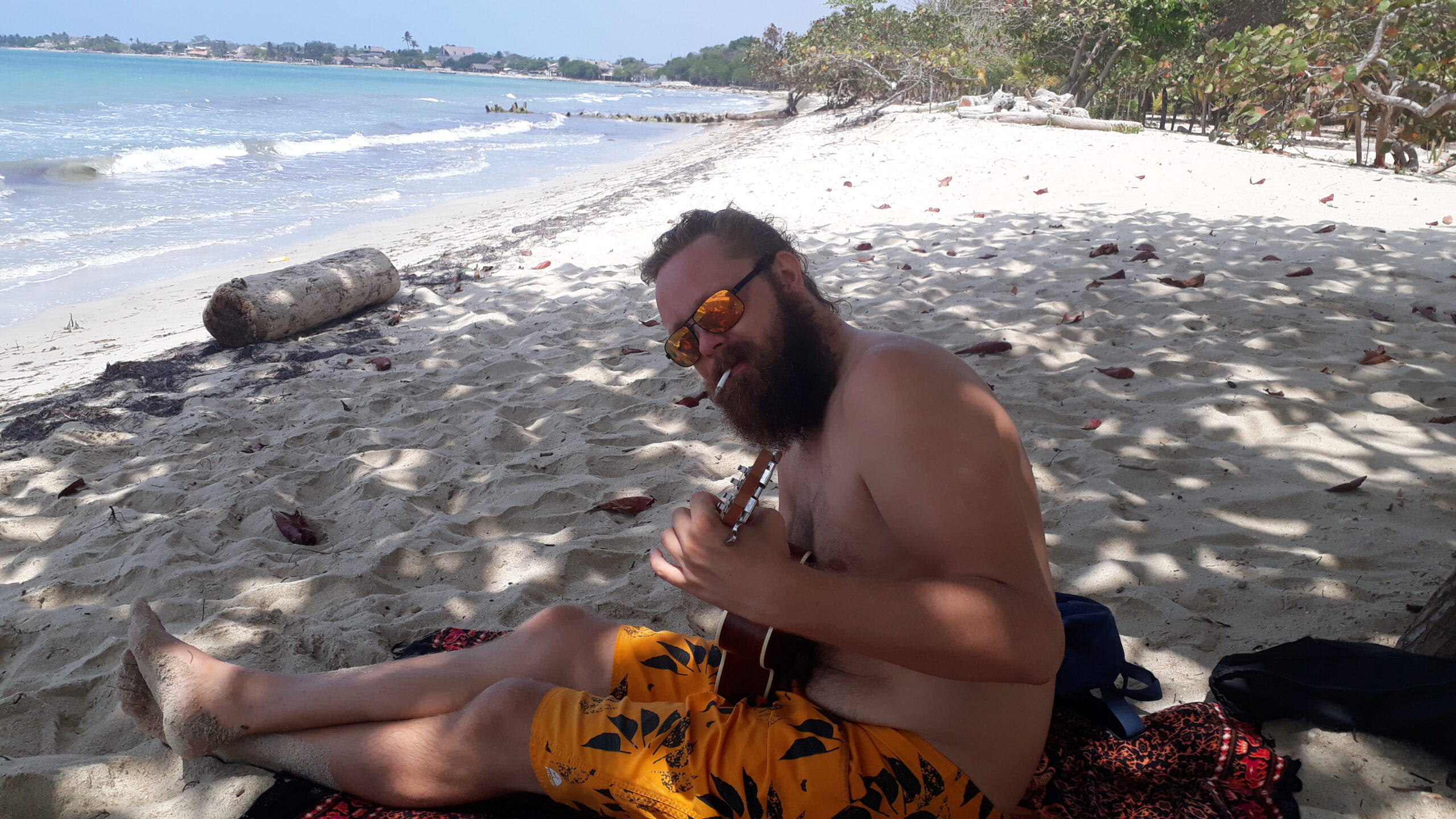 Raymond hadde god tid i utlandet. Her prøver han å lære ukulele på en strand i Columbia.