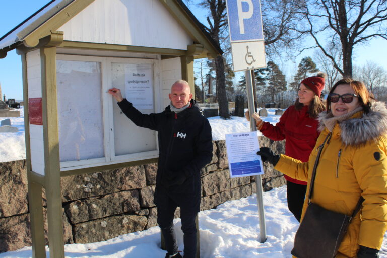 Thomas Melby Hee, Vilde Strid og Karin Flikkeid fra avdelingen for tilpasset kultur hengte på torsdag opp startposten på den nye rebusløypa i Øvrebyen på Kirketorget.