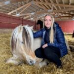Eier og drifter av Krogsrud Gård og Hestesenter, Line Brodahl. Her flankert av Odin, en av sine trofaste «ansatte».