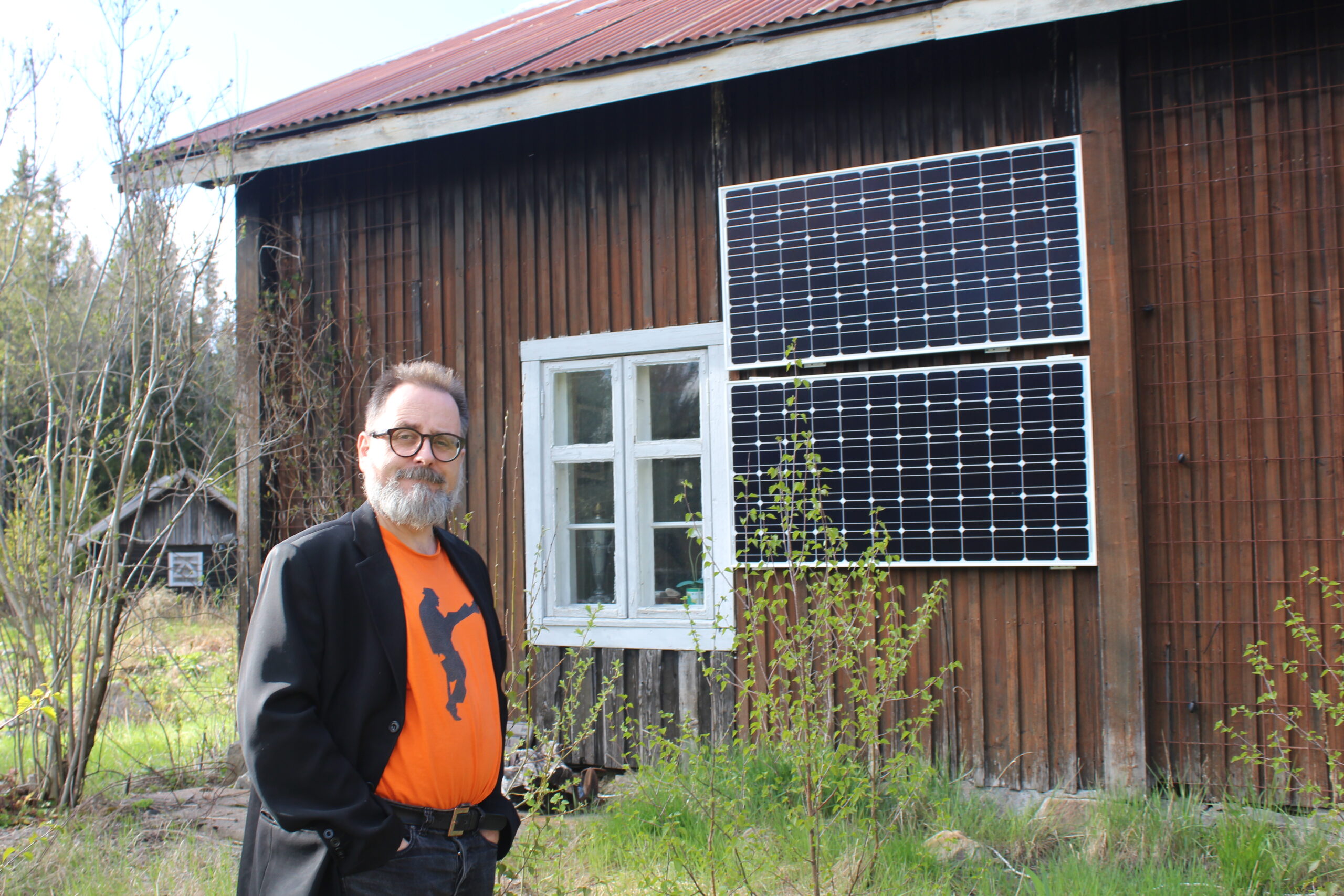 For to år siden satte han opp to solcellepaneler på sørsiden av hovedhuset. Han åpner et skap i stua og viser hvordan det hele funker.