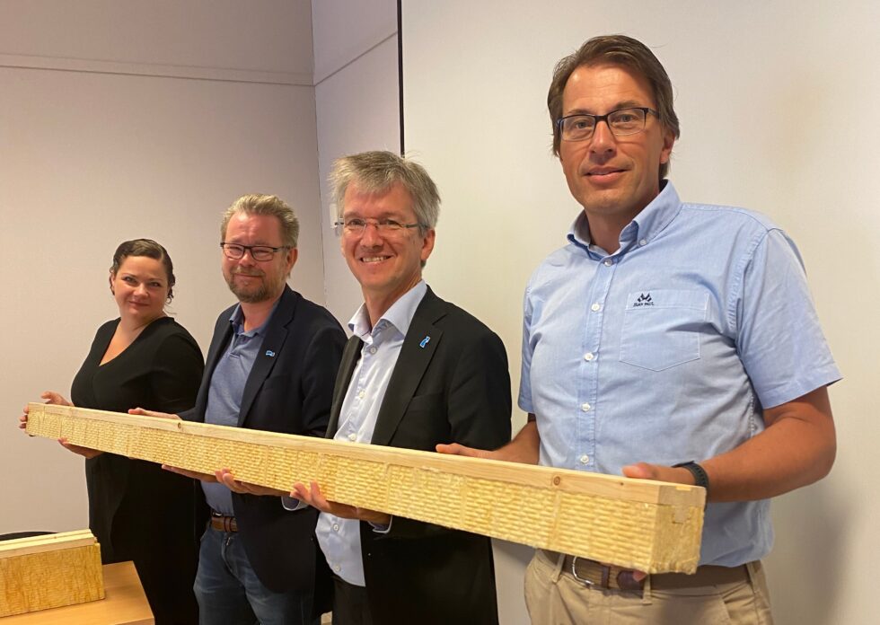 Direktør Erik Nilsen (t.h) og ordfører Margreth Haarr kunne fortelle Statssekretærene Paul Schaffey (t.h) og Raymond Robertsen om et nytt treprodukt for byggeindustrien utviklet der skogen faktisk vokser.