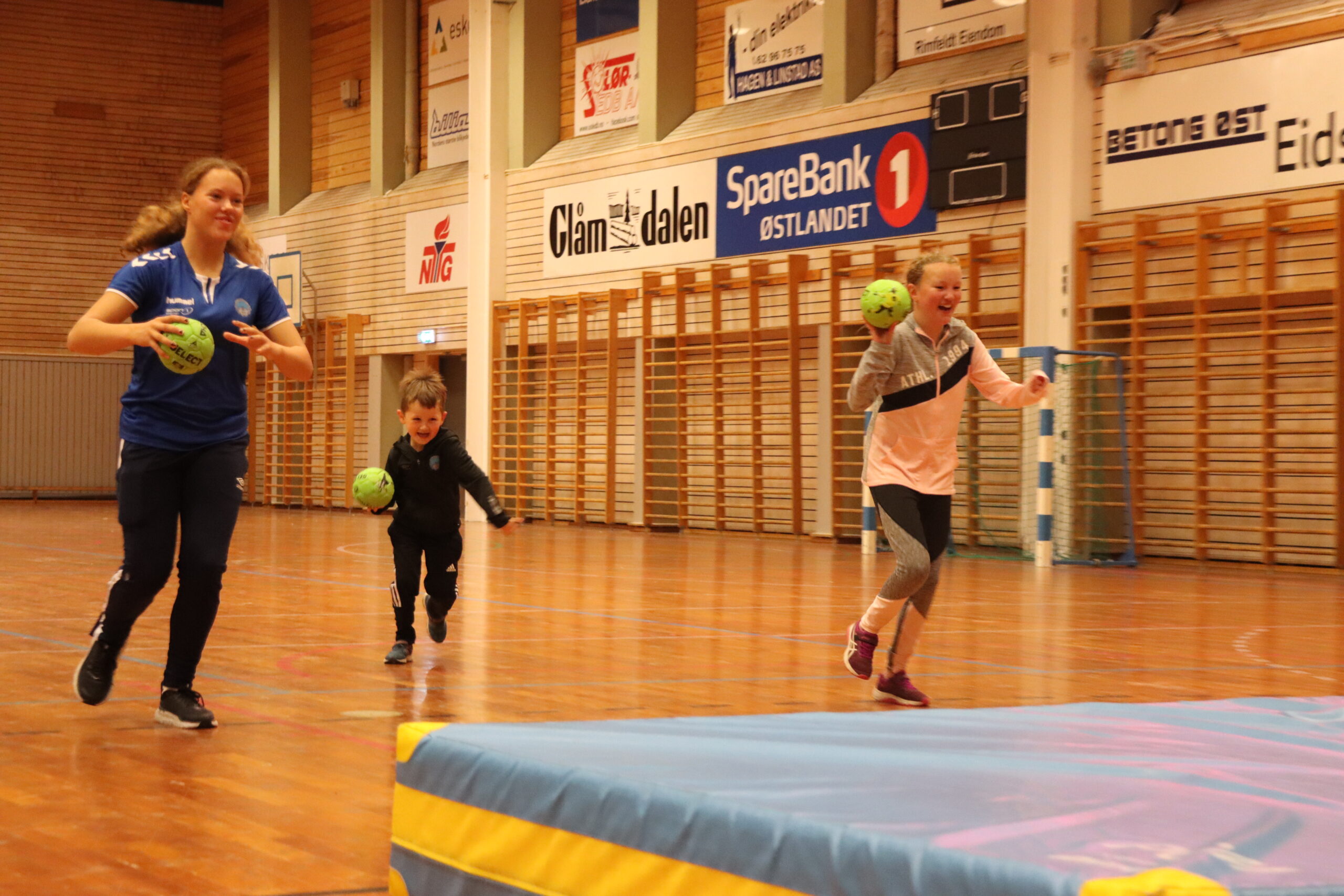 Daniel (6) og Anja Engedal Jensen (11) besøkte håndballen i Tråstadhallen, her sammen med Mille Johnsen (t.v.). Daniel på 6 år sier han bare har prøvd på skolen før.