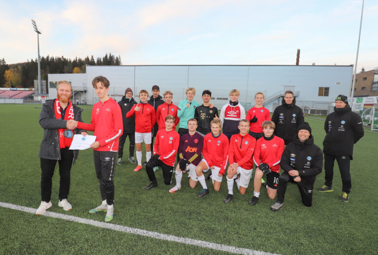Eirik Kalland tar i mot sjekken fra Lars Erik Fremming. Jørn Karlsrud (b.v.), August Hellerud Fjeld, Jon Inge Høiland, Kristian Rambøl, Odin Høiland, Erijon Thaci, Lukas Strandseter, Albert Leer Sandstad, Peder Kalland, Hans Jørgen Hansen, Simen Takle-Hagen (f.v.), Jakob Eikbråten, Martin Strand Johnsen, Henrik Hansen, Andreas Talberg Berger og Håkon Leer Sandstad ser frem til en spennende finalehelg. Philip Myrvold Gundersen, Sebastian Rovik Johansen og Didrik Baanerud var ikke tilstede da bildet ble tatt.