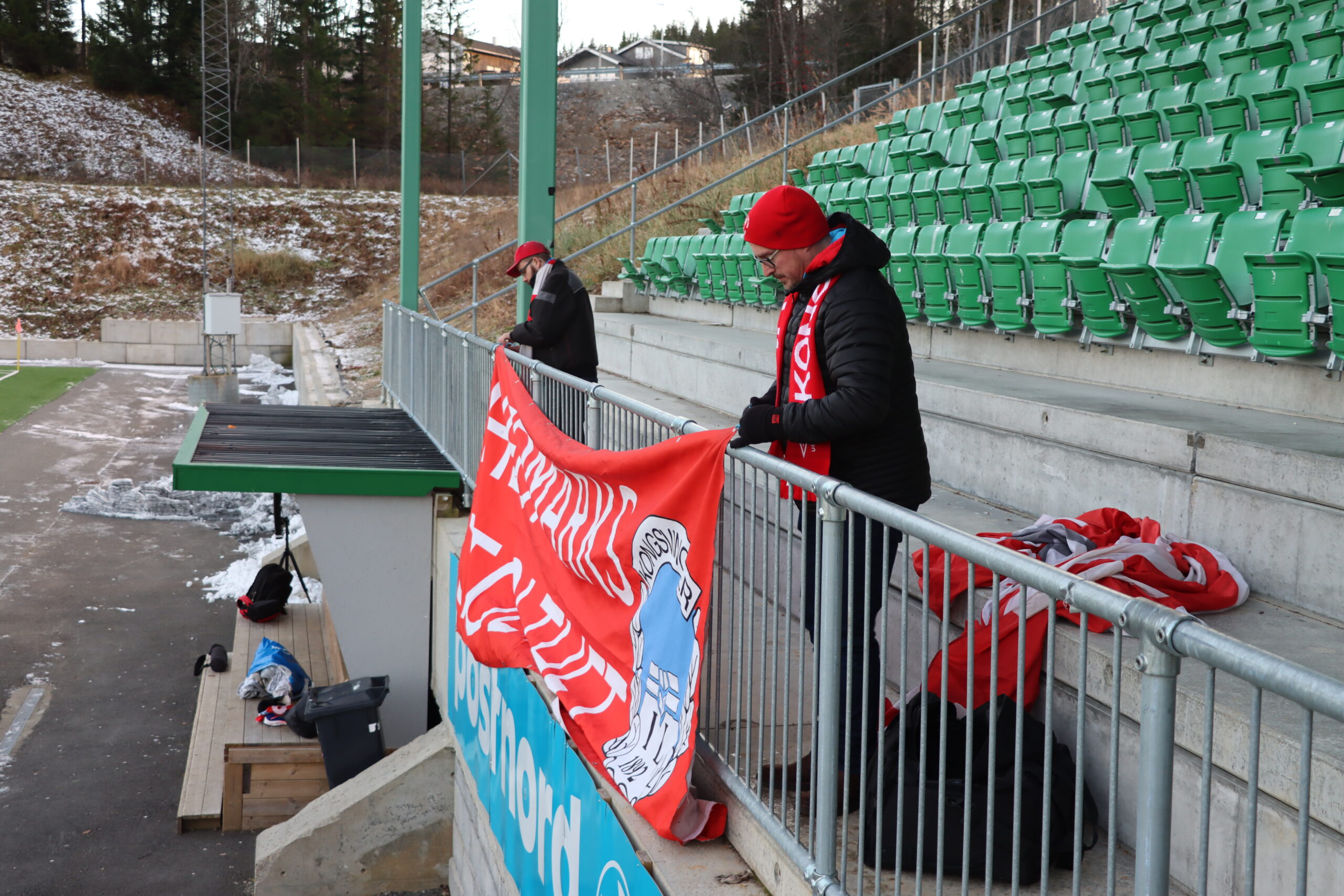 Hans Christian Sjøli og Morten Fossmellem på plass på Fløya Arena med banneret.