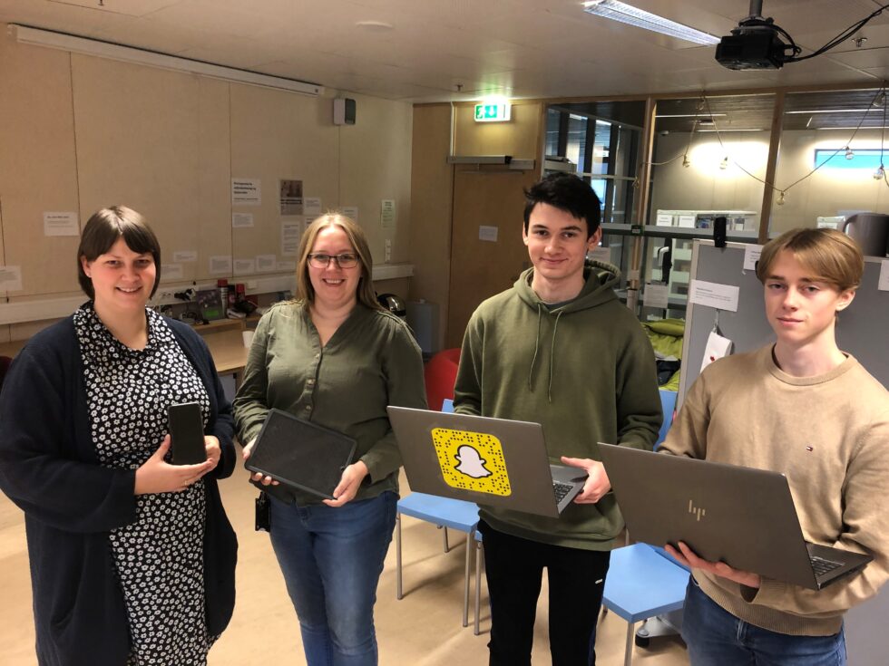 Bibliotekar Marianne Skog Eltvik (t.v.), skolebibliotekar Marte Østmoen, Moritz Myrseth og Sondre Erichsen tar imot folk som måtte trenger teknologisk hjelp på torsdager.