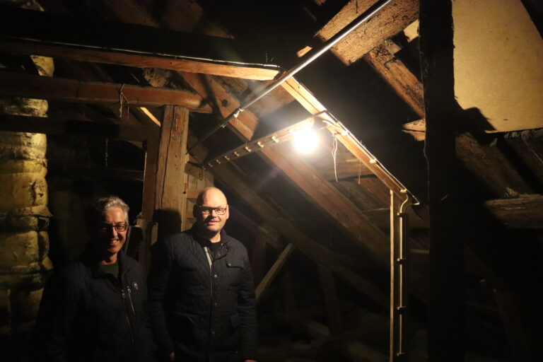 Huseier Ronny Ruud (t.h.) og fagleder Andreas Fuglum inspiserer sprinker-rør på loftet i Ruuds hus i Øvrebyen. I år bruker kommunen og Riksantikvaren til sammen to millioner kroner på slike anlegg i andre bygg i Øvrebyen.