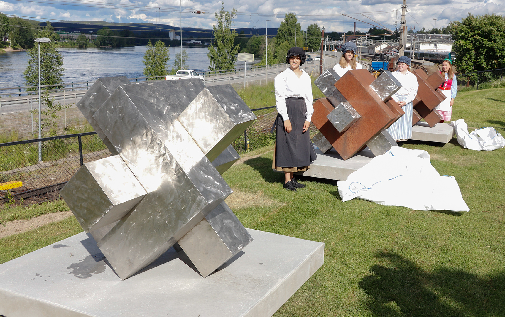 De tre støtteskulpturene, her flankert av medlemmer av årets oppsetning av Eventyrfestningen.