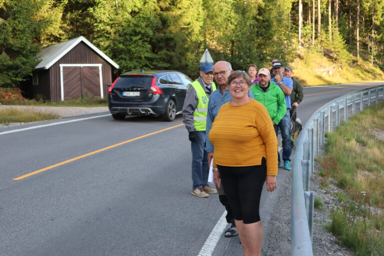 Innbyggerne på Øyermoen kvier seg for å gå tur gjennom grenda med E-16 som eneste vei. Fra høyre: Eli Smedtorp, Paal Øieren, Hilde Røttum, Lars Helge Røttum, Ludvik Henden, Per Arne Eriksson med elghunden Kodiak, Trond Øieren, Marit Dahl og Henry Pelsholen viser her hvor liten plass det er for fotgjengere gjennom Øyermoen langs E-16,
