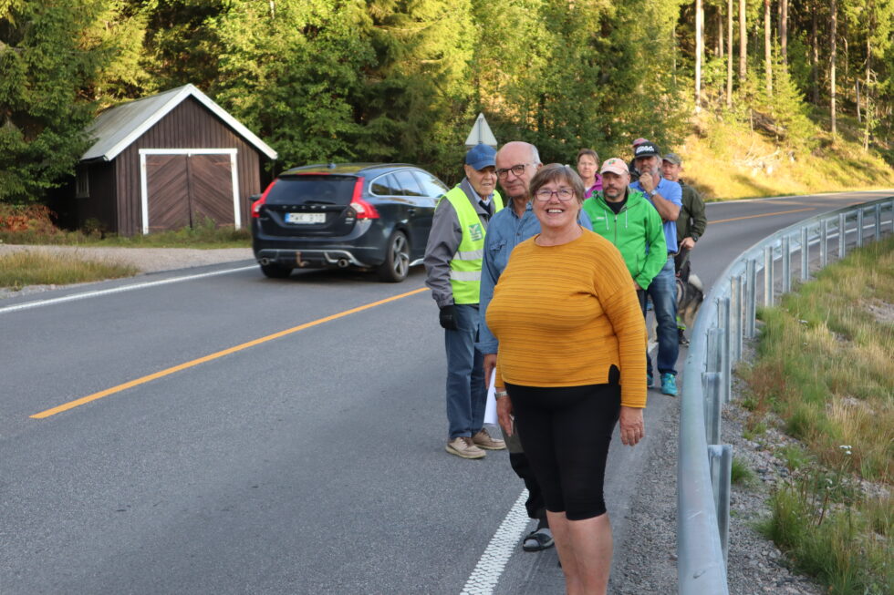 Innbyggerne på Øyermoen kvier seg for å gå tur gjennom grenda med E-16 som eneste vei. Fra høyre: Eli Smedtorp, Paal Øieren, Hilde Røttum, Lars Helge Røttum, Ludvik Henden, Per Arne Eriksson med elghunden Kodiak, Trond Øieren, Marit Dahl og Henry Pelsholen viser her hvor liten plass det er for fotgjengere gjennom Øyermoen langs E-16,