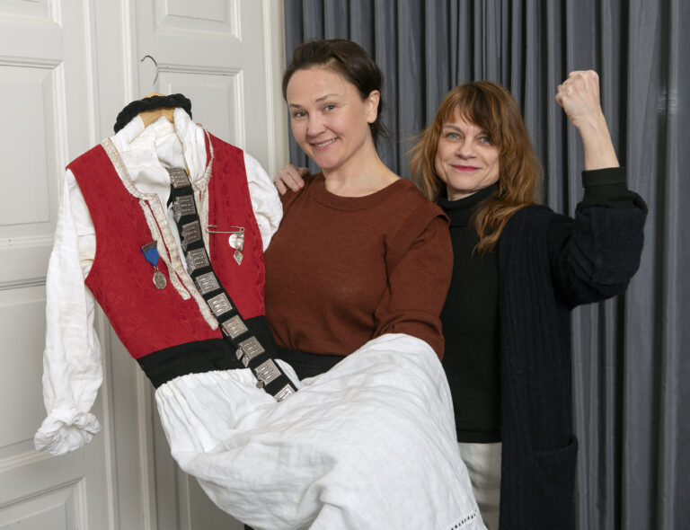Anja Cecilie Solvik (t.v.) fra Bunadsgeriljaen overleverer selveste geriljalederbunaden til Anno Kvinnemuseet ved fagansvarlig Hilde Herming.