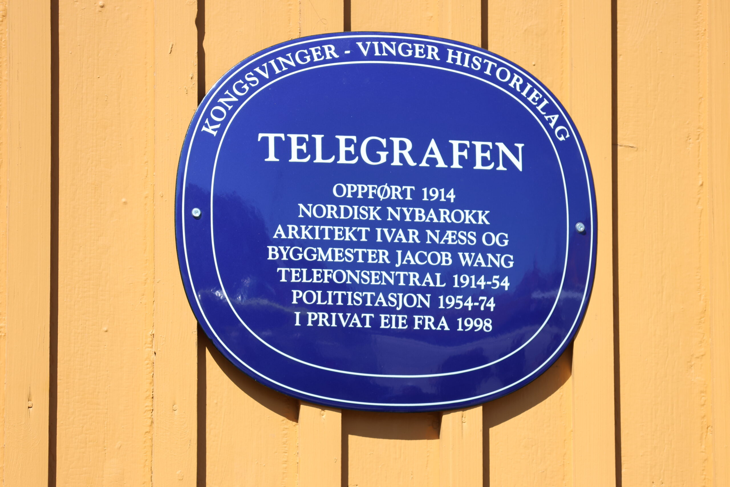 Det blå skiltet inneholder bygningens historikk i kortforrm.