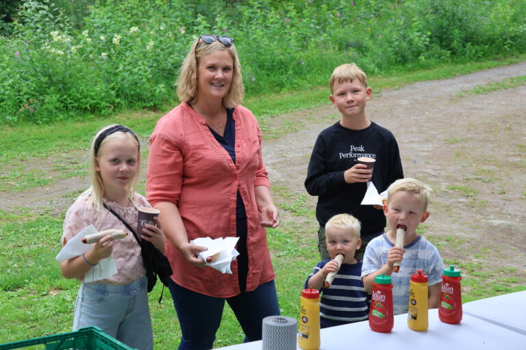 Familien Rungren med Oline (f.v.) Silje, Emil, Alfred og Ola hadde tatt turen ned til badeplassen på Brandval og fikk servert nystekte grillpølser.