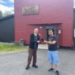 Kjetil Foseid er en av mange som bidrar med premier til Husets store lotteri. Lars Ovlien tar i mot premien på vegne av Huset. .