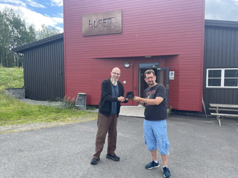 Kjetil Foseid er en av mange som bidrar med premier til Husets store lotteri. Lars Ovlien tar i mot premien på vegne av Huset. .