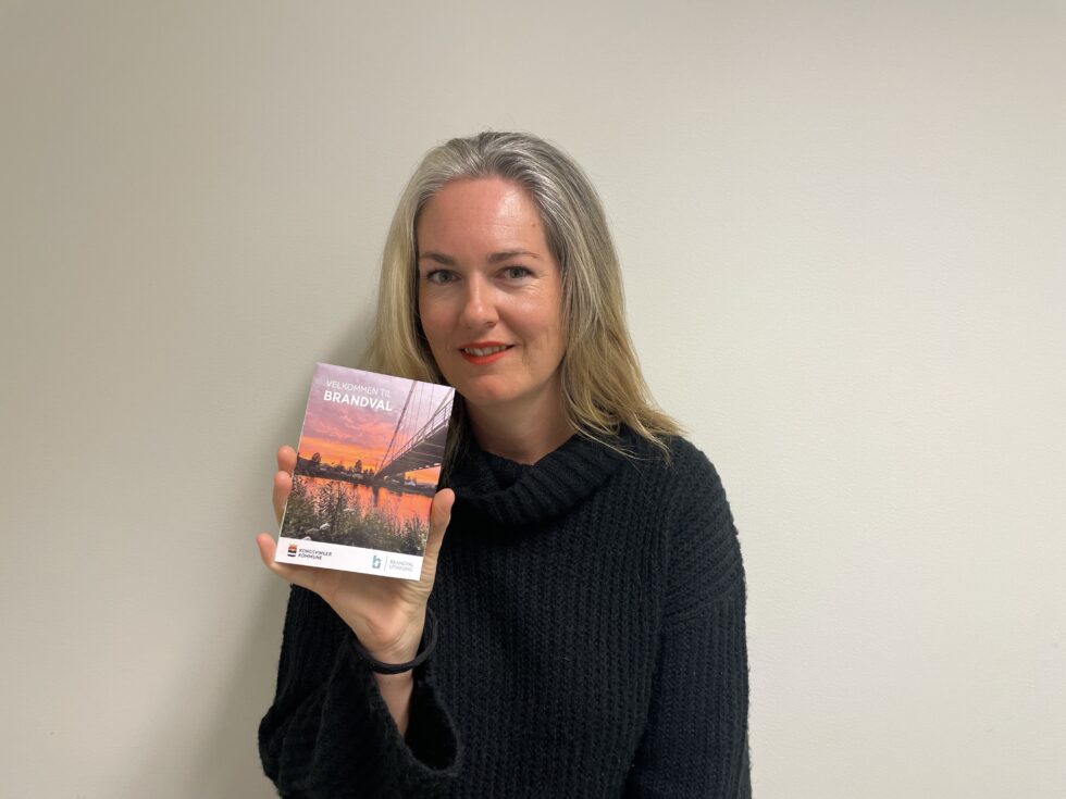Brandval Utvikling har i høst gitt ut en ny brosjyre om Brandval. Her viser leder i Brandval Utvikling Ann Kristin Torgersen Aamodt frem produktet.