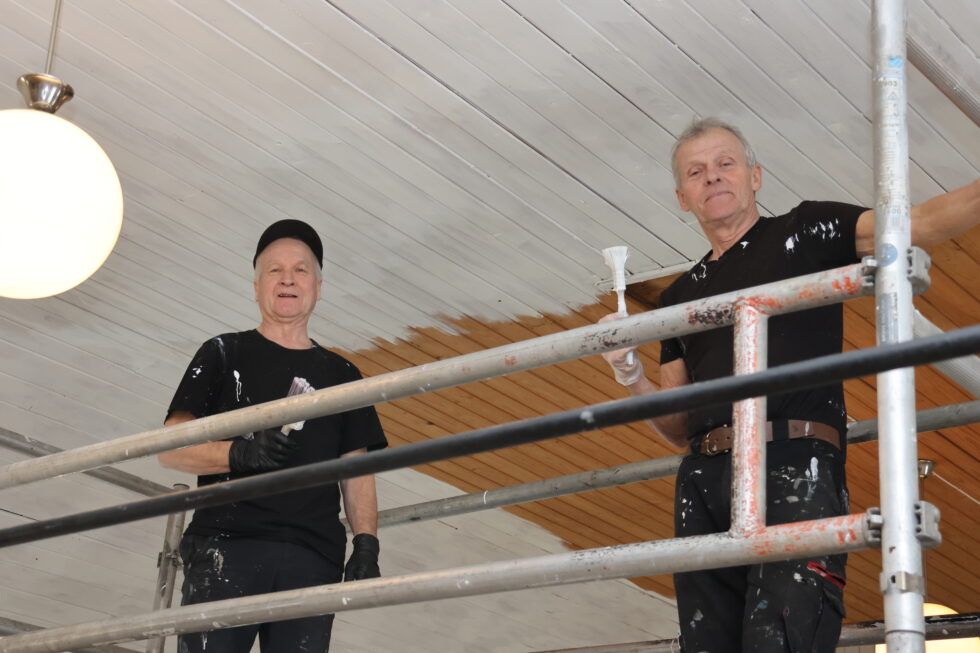 Kjetil Moe (t.v) og Tor Solbergseter sørger for at den gule panelen blir hvit. Når arbeidet er ferdig regner karene med å ha brukt 85 liter maling.