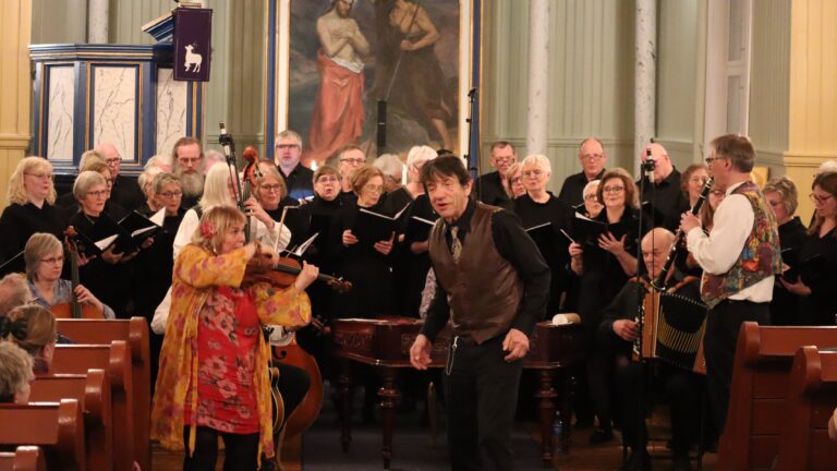 Det var mange på scenen da Austmarka bygdekor hadde konsert sammen med Grue Finnskog sangkor, skuespilleren Helge Jordal og Gjertruds sigøynerorkester.