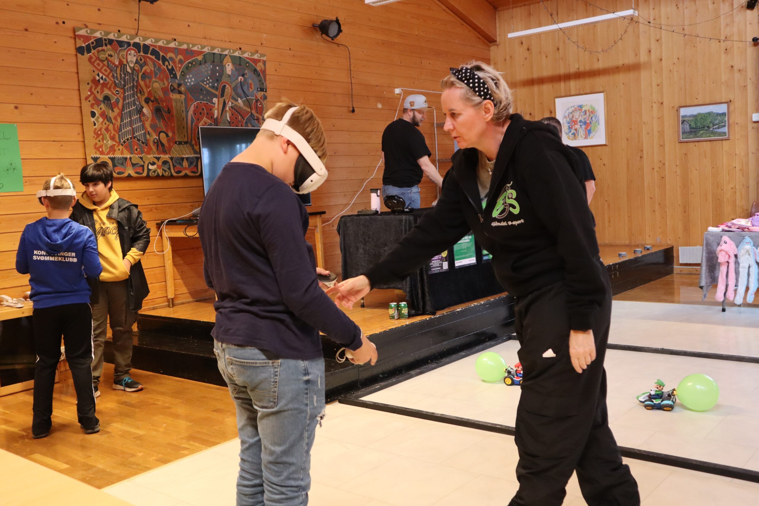 Gl&aring;mdal E-sport stilte med VR-briller, Mario Racing og Nintendo Switch og blaze pads. Her hjelper leder i Gl&aring;mdal E-sport, Laila Johansson til med VR-brillene.