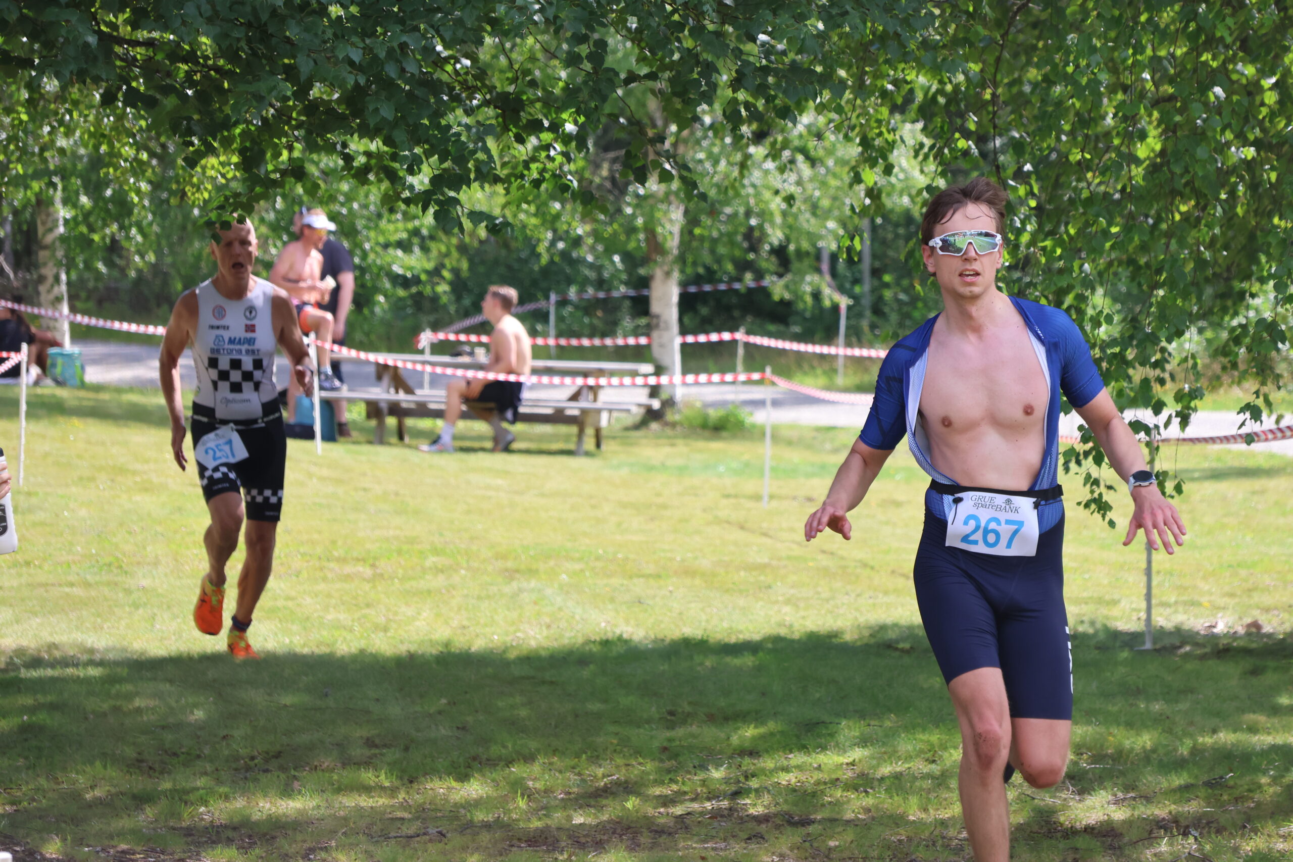 Rolf M. Bakken i bakgrunnen, med nummer 257 p&aring; drakta ,p&aring; vei inn i m&aring;lomr&aring;det etter &aring; ha gjennomf&oslash;rt Finnskogen Triatlon.