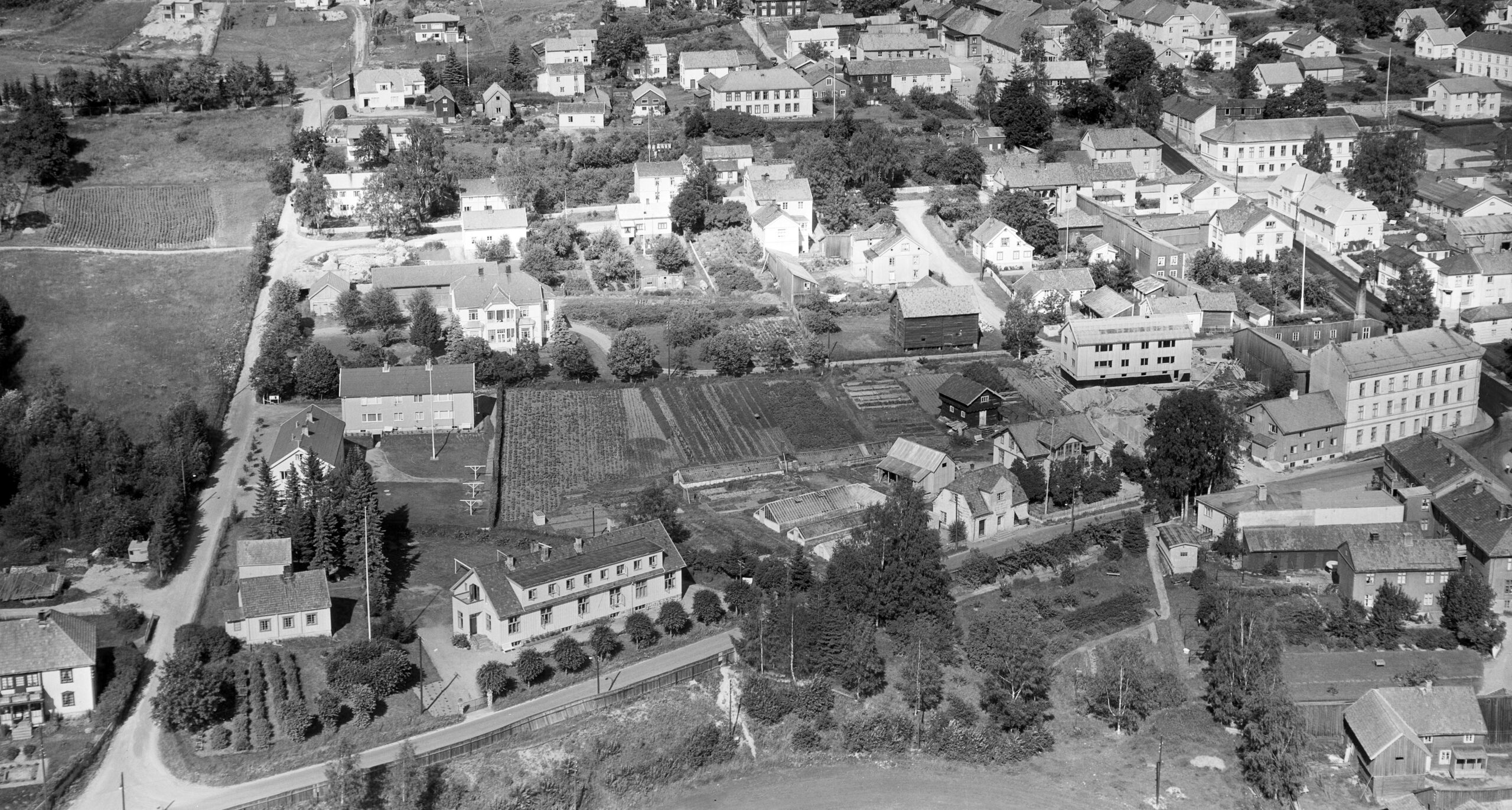 Slik så Kongsvinger Handelsgartneri ut i 1955. Drivhusene er de samme som O. A. Hexum bygde på 1800-tallet. Butikken var i murhuset ut mot Torvgaten (senere Øvre Langelandsvei), og trevillaen var bolighus.