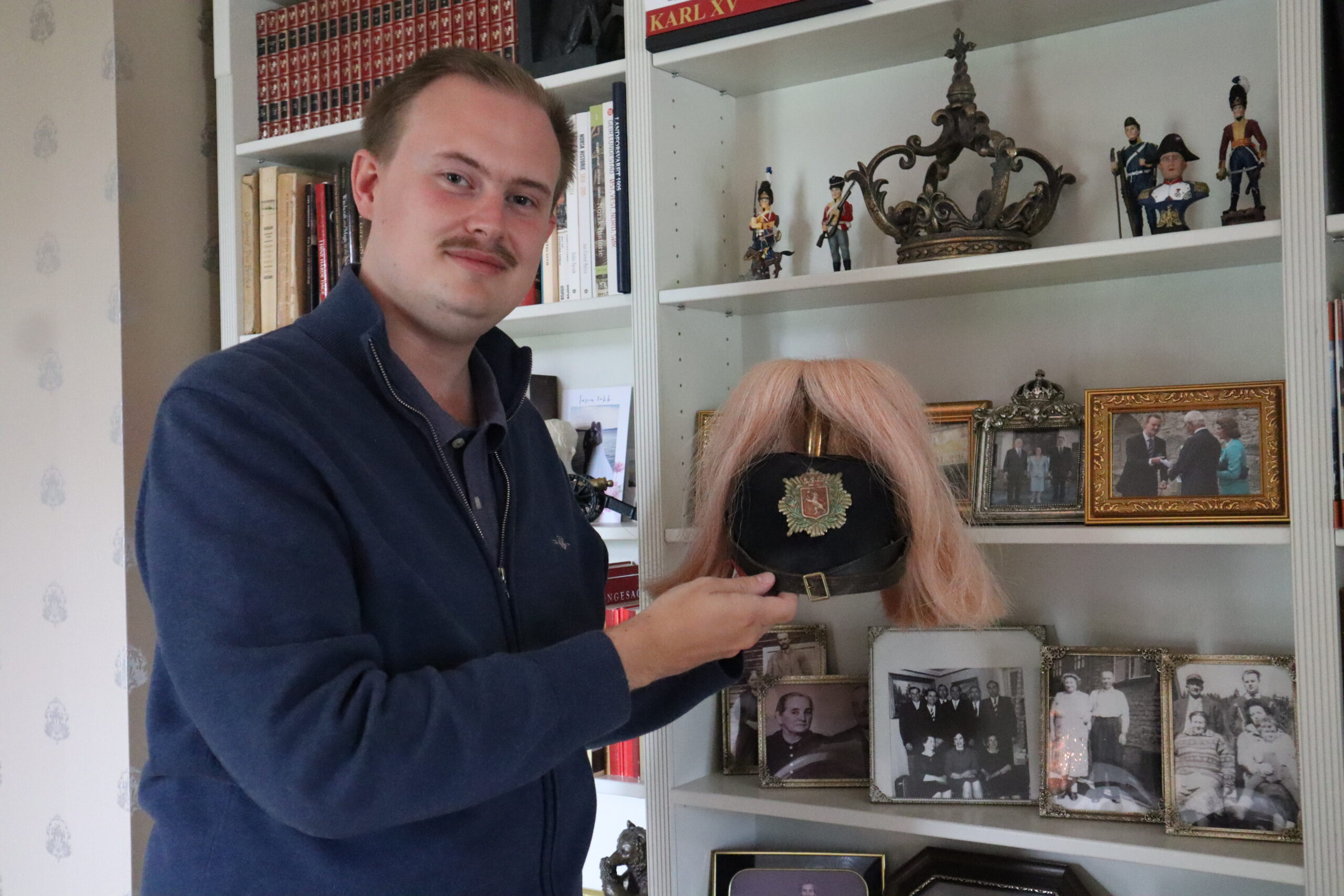 Oskar samler på militære hodeplagg, og hans lille private samling er nøye plassert på toppen av bokhylla.
– Dette er en offiser infanterihjelm fra cirka 1880 her i Norge. Denne dusken var opprinnelig knallrød, og er av hestehår, forteller Oskar.