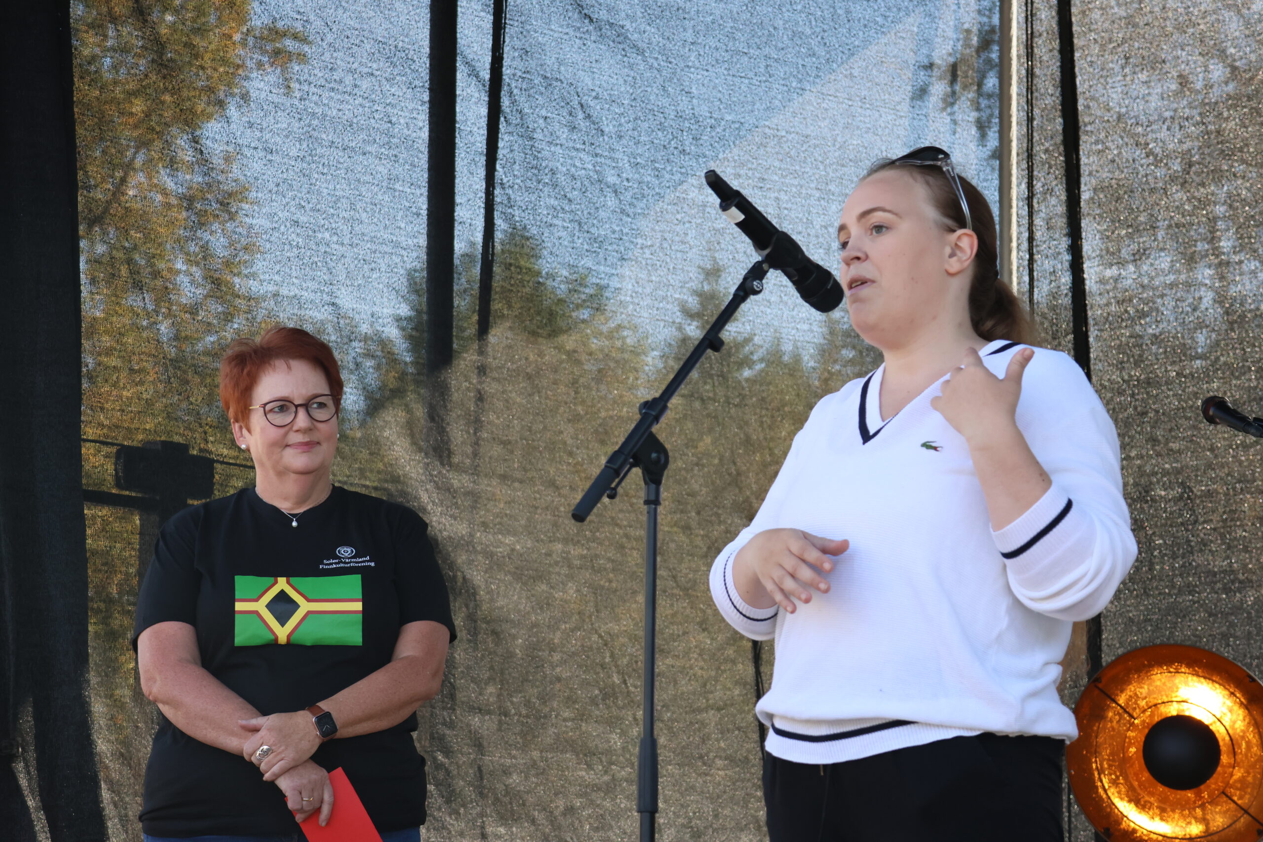 Ordf&oslash;rer Elin S&aring;heim Bj&oslash;rkli med det skogfinske flagget p&aring; brystet &aring;pnet &aring;rets Silppufestival. Festivalgeneral Maja Strand introduserte.