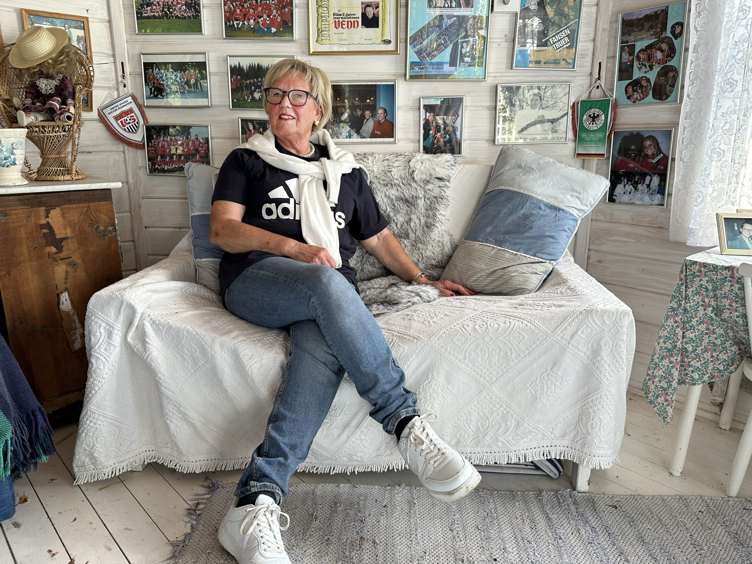 I ett av husene p&aring; sm&aring;bruket er den ene veggen dekorert med bilder som minner Elisabeth p&aring; mange av de gode opplevelsene fra tiden innen fotballen.