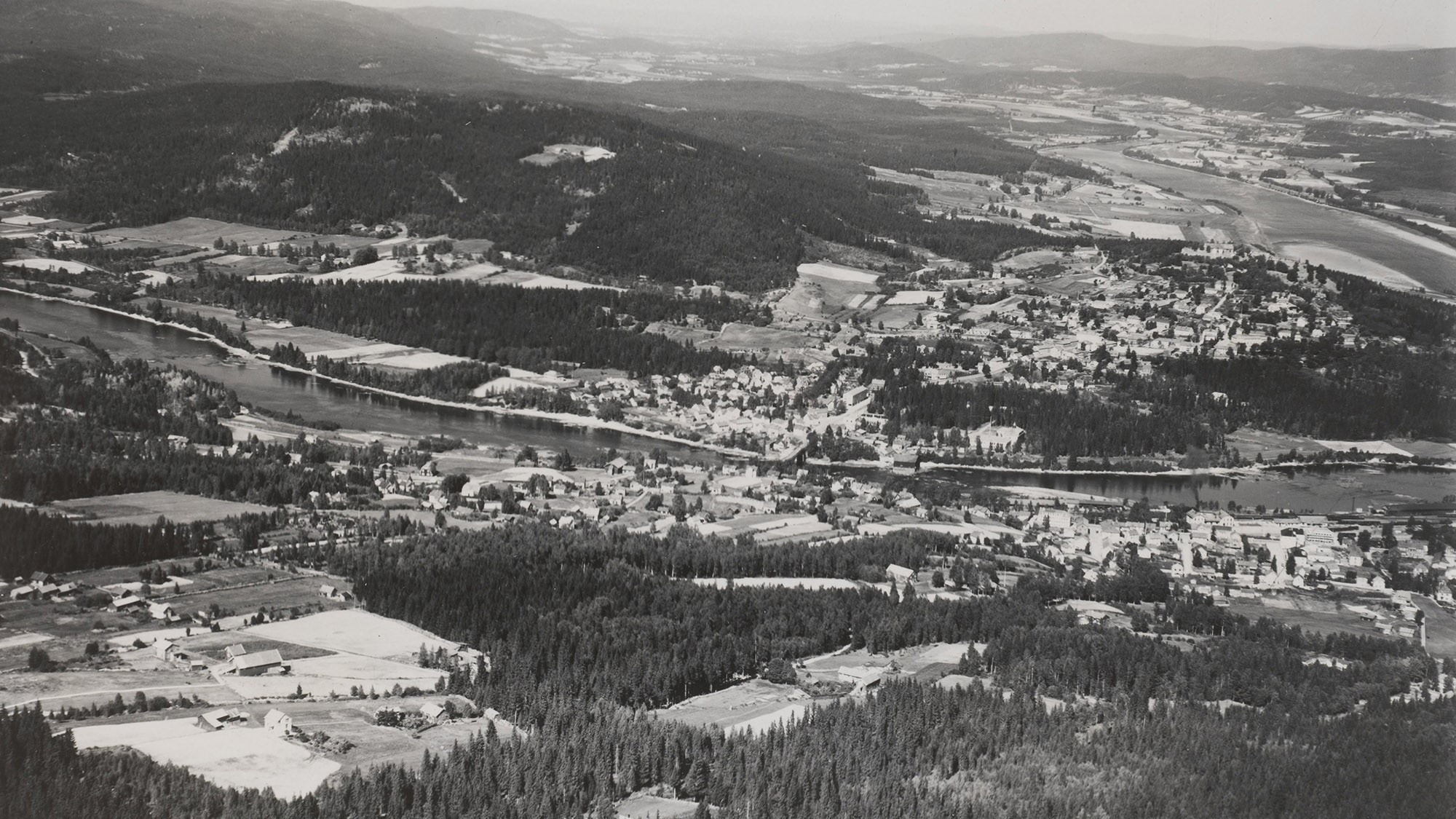 Flyfoto fra Widerøe sommeren 1947. KOBBL-bygget midt i bildet. Bebyggelsen er for det meste innenfor grensene etter utvidelsen av Kongsvinger i 1875, da stasjonssiden ble innlemmet i bykommunen. Utenfor er det mest jorder, skog og utmark.
