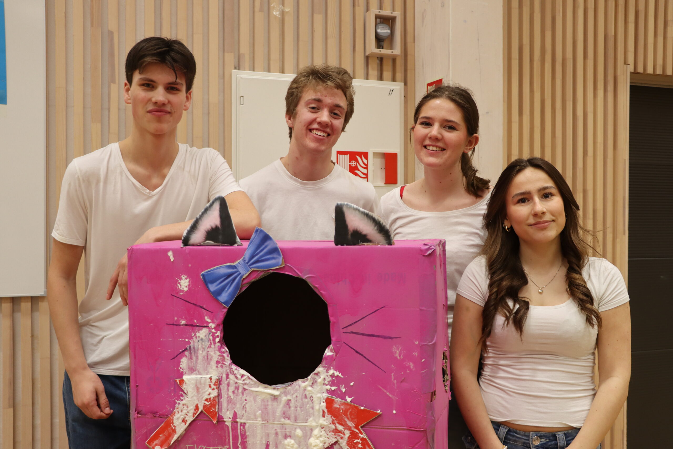 Theo Hole Haglund (16) (f.v.), Ludvik Arnesen Kalland (16), Anja Sophie Hoffmann (16) og Alette Snapa (16) lot folk som svarte riktig på spørsmål om temaet deres kaste krem på dem i maskoten "fløtepus".