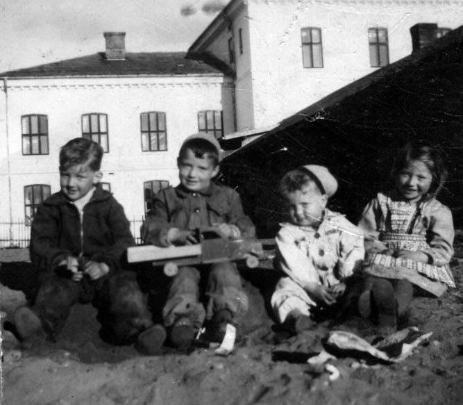 Bildet tatt med Øvrebyen videregående skole i bakgrunn rundt 1950. Fra venstre: Bjørn Humborstad, Bjørn Aarstad, Per Tore Broen og storesøster Grete Broen.