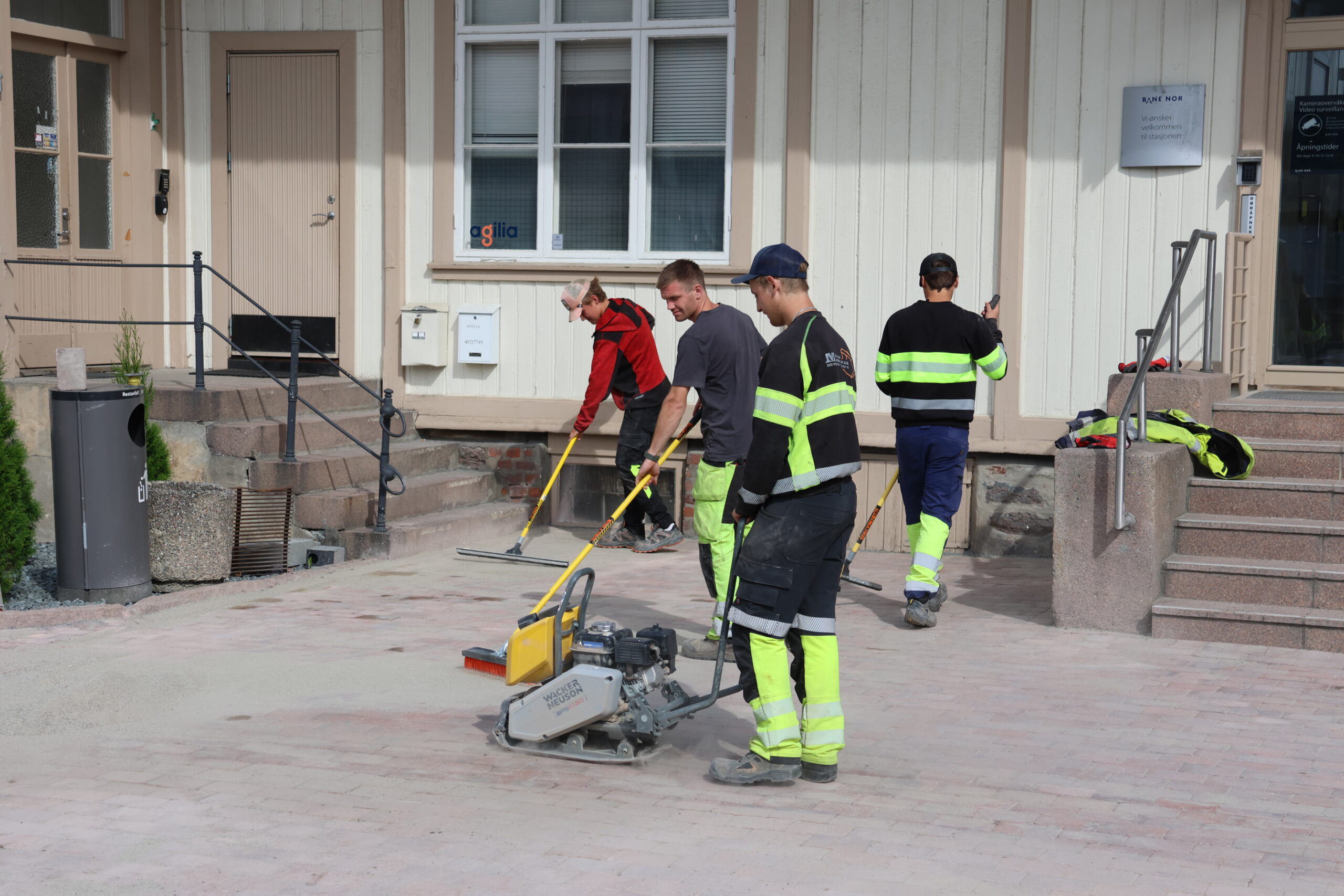 Det er utf&oslash;rt mye arbeid p&aring; stasjonstomta. Blant annet er 600 kvadratmeter med beleggningstein plukket opp, renset og lagt igjen. Her har Simen Tuhus styr p&aring; hoppetussa, mens Simon Melby, Alexander Smedtorp og Anton Aurbakken hiver p&aring; fugesand mellom steinen.