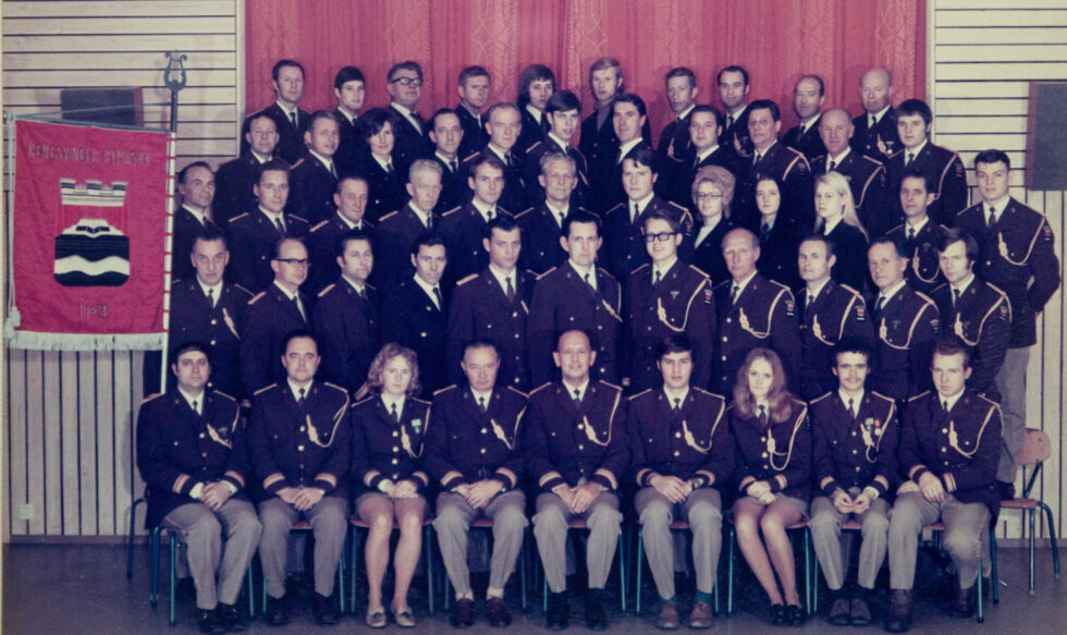 Bymusikken i 1972. Foran fra venstre: Oddvar Taje, Hans O. Hansen, Gudny Hagen, Kristian Nøkleby, Gunnar Biller, Øyvind Torgersen, Per Ola Flikka og H. Hermansen. Andre rad: S. Hansen, Rolf Sandhalla, Ola Karlstad, Harry Hansen, Sverre Eik, Leif Johansen, O. Hallgren, Rolf Skyrud, Alfred Bukkåsen og Knut Pedersen. Tredje rad: Reidar Monsrud, G. Løvheid Hansen, Andreas Hansen, Bjarne Gaukstad, Jan Arne Svendsen, H. Myhre, Rolf Devik, Bodil Midthun, Torill Nybråten, May-Kristin Strand, S. Hellerud og Åge Lilleseth. Fjerde rad: Gunnar Gylterud, Egil Bjørkli, Ulla Torgersen, Knut Runningen, Bjørnulf Johnsrud, J. K. Aker, Werner Svartberg, Martin Albertsen og Svein Sjølie. Bakerst: Leif Erling Arnesen, Sigmund Ruud, Asbjørn Lilleseth, Kjell Disen, Tore Sjølie, Gunnar Høgberg, Sigmund Reksnes, Torfinn Tronstad og Rolf Pedersen.