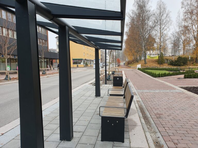 Taket over benkene på bussholdeplassene i Storgata beskytter ikke de sittende mot nedbør.