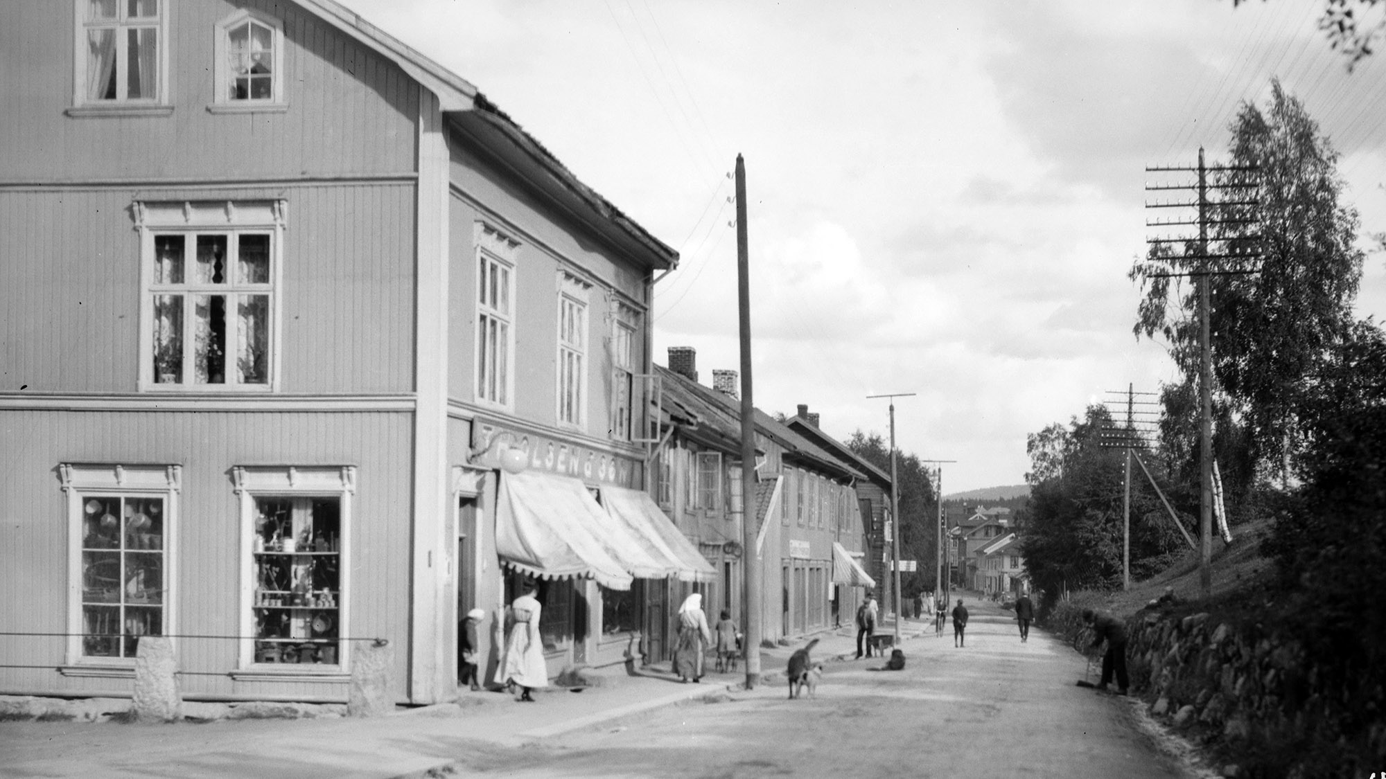 Glommengata sett fra bybrua ned mot jernbanestasjonen. Nærmest ligger forretningen «Th. Olsen & Søn», som fikk navnet i 1909.