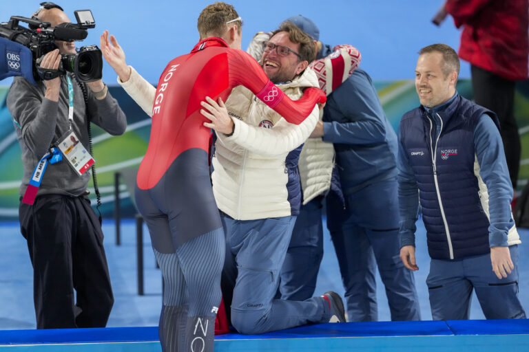 Arnstein Storås (t.h.) fikk oppleve søndagens OL-gull til Sander Eitrem fra nært hold. Nemus-fysioterapeuten er også fysioterapeut for skøytelandslaget.