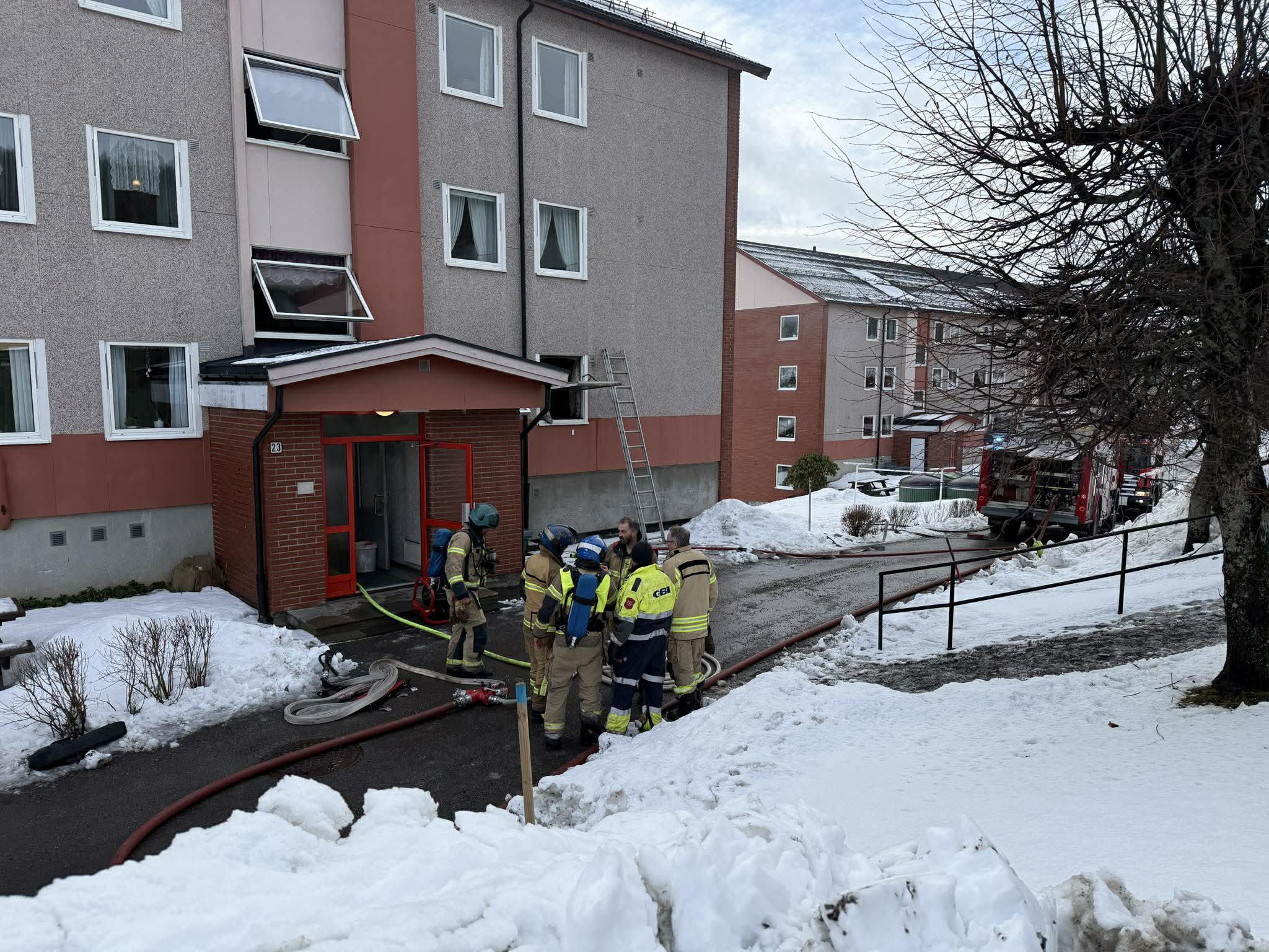 Mannskaper fra Brannvesenet er i gang med utlufting av røyk etter branntilløpet i en boligblokk på Langeland.