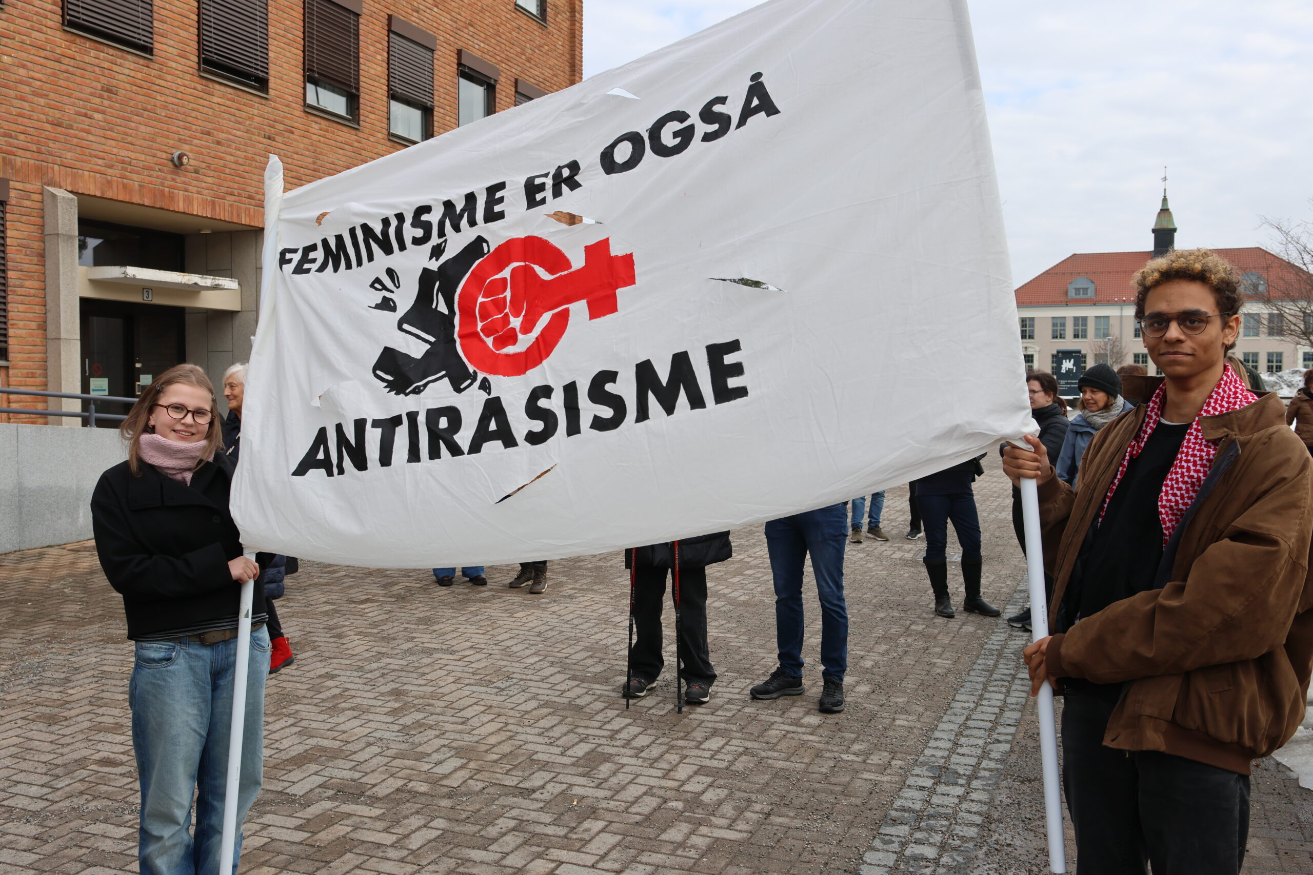 Hulda Pauline Mamen Greger og Sigur Elias Neuberg med fanen "Feminisme er også antirasisme".