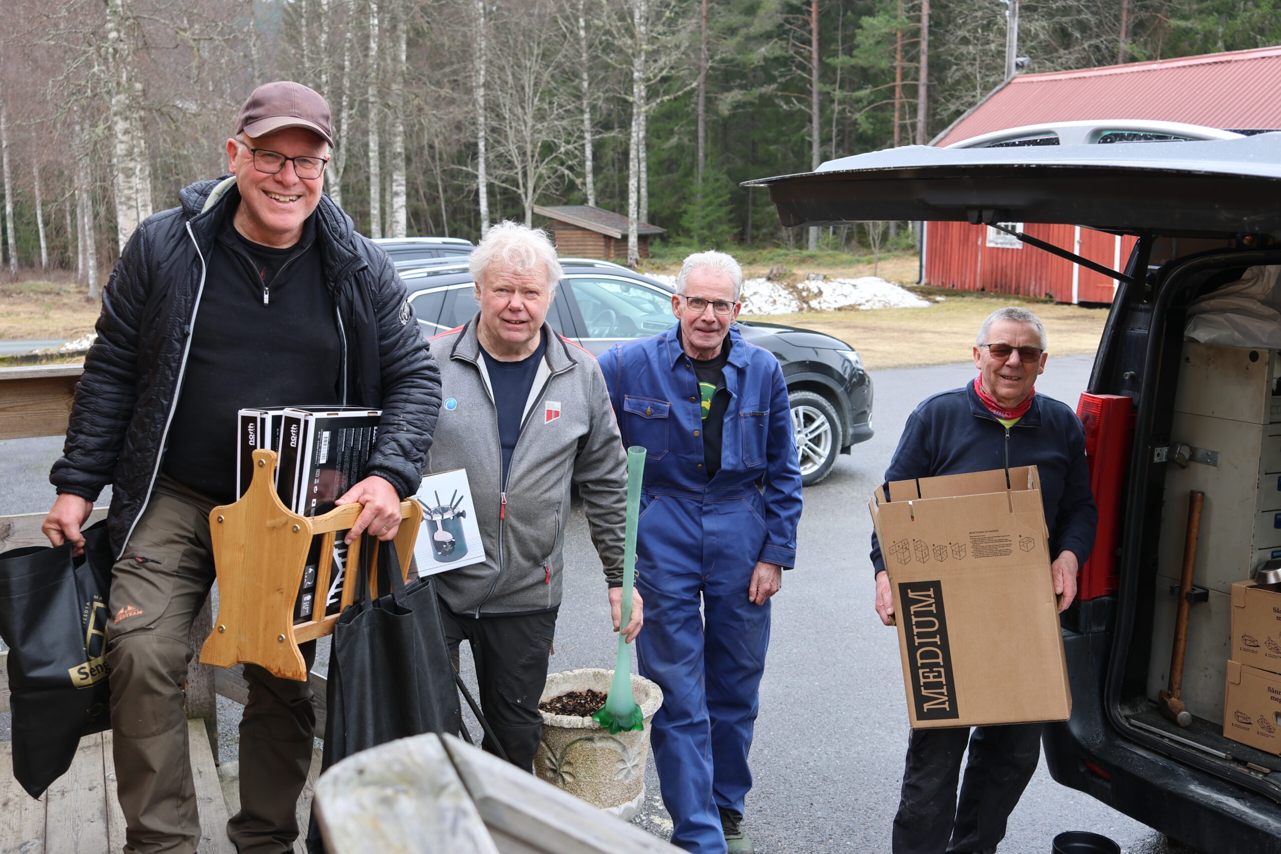 Geir Verhaug (t.v.), Steinar Narvesen, Gunnar Kristiansen og Per Moe tømmer en varebil full av lopper som skal selges til helgen. Alt til inntekt for Granli bygdehus.