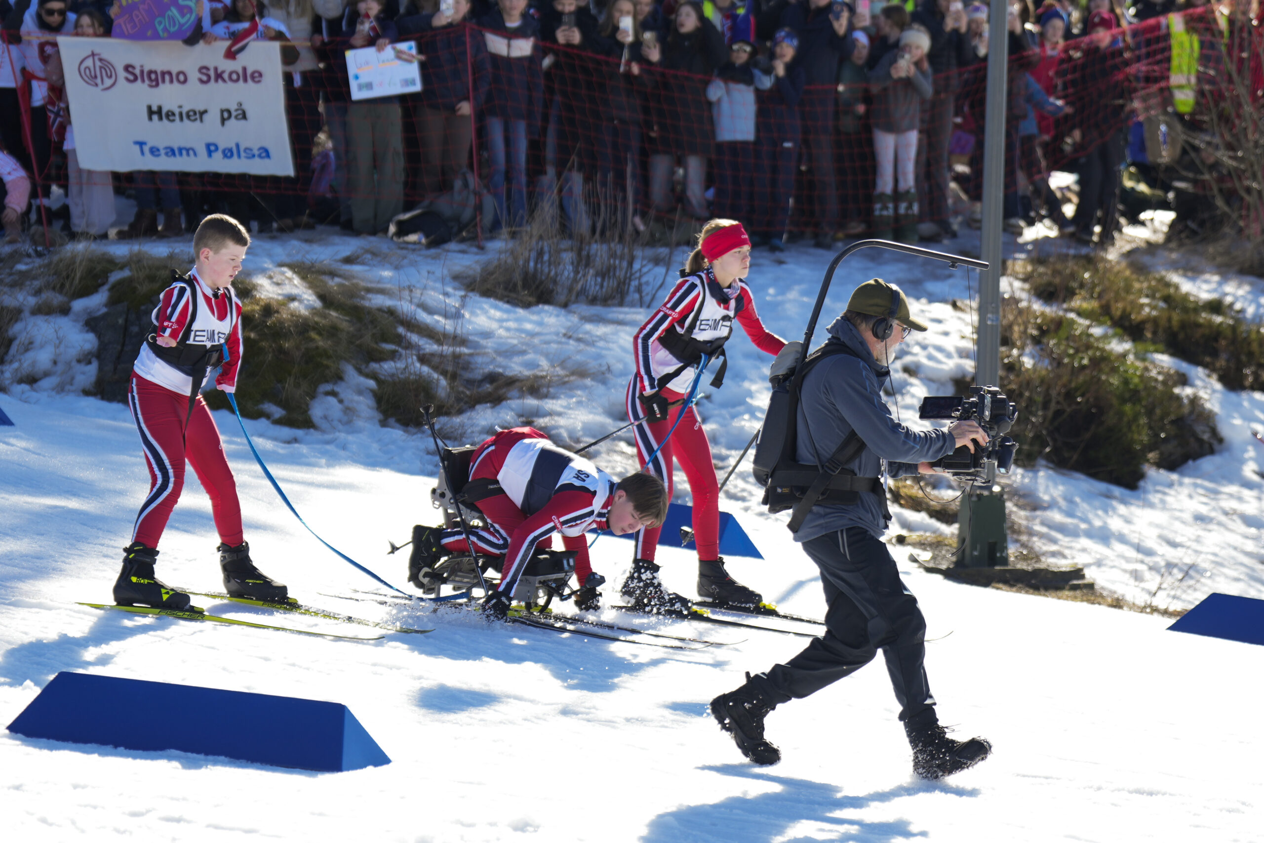 Publikum heier frem Kornelius Smeby-Ryen og resten av Team Pølsa, mens NRK-teamet følger med på sidelinjen med tv-opptak.