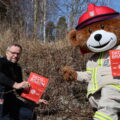 Leder for forebyggende avdeling i Glåmdal Brannvesen IKS, Per Harald Bekken og brannbamsen Bjørnis minner om det nasjonale bålforbudet som gjelder frem til 15. september.